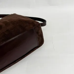 Close-up detail of dark brown suede tote bag showing texture and leather stitching craftsmanship.