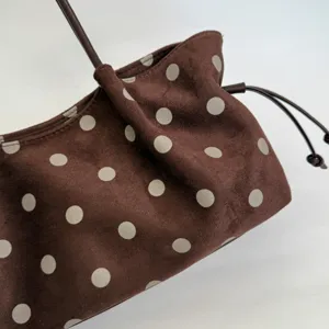 Brown polka dot suede tote bag detail, featuring soft texture and stylish drawstring design.