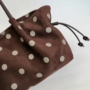 Close-up view of the brown polka dot pleated tote bag, showing soft suede texture and details.