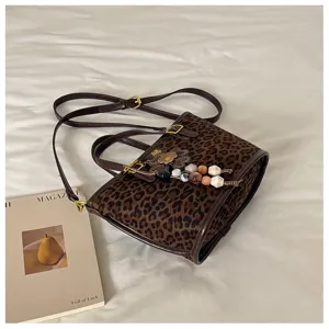 Chic leopard print tote bag with shoulder strap and stylish charm pendant for women.