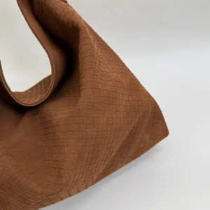 Nahaufnahme der braunen gewebten Umhängetasche, zeigt hochwertige Textur und Design.