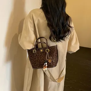 Stylish leopard print tote bag with shoulder strap and chic flower charm, casual and versatile design.