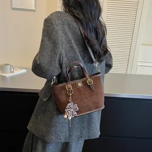 Brown suede tote bag with shoulder strap and flower charm, casual stylish handbag for women.