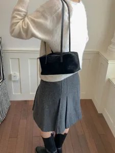 Black suede shoulder bag detail, vintage underarm pillow bag with long strap for daily commute.