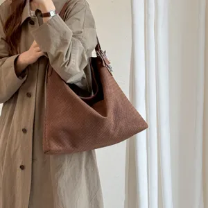 Detailansicht der braunen geflochtenen Lederschultertasche, lässiges Design mit viel Stauraum.