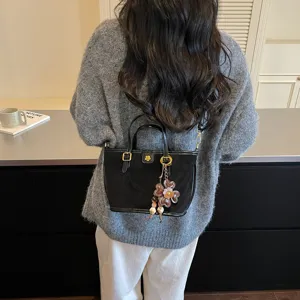 Black suede tote bag with floral charm, stylish shoulder crossbody bag for women daily wear.