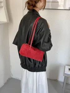 Retro red suede shoulder bag for women, stylish underarm bag with long strap for daily commute.