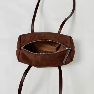 Brown suede pillow shoulder bag detail, long straps, top zipper closure, chic everyday purse.