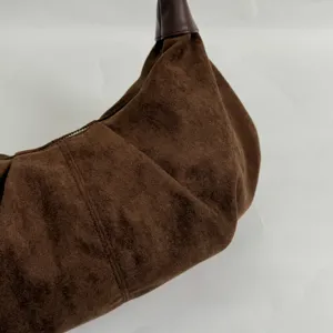 Braune Wildleder Hobo Umhängetasche Detailansicht mit weichem Falten Design und Reißverschluss.