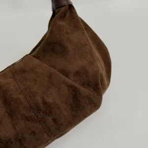 Braune Wildleder Hobo Bag Detailansicht, weiche Textur, Retro Stil und feine Nahtdetails.