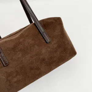 Brown suede shoulder bag detail, vintage chic pillow bag with dark leather straps for women.