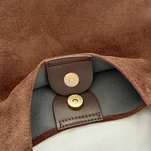 Brown suede HOBO handbag detail featuring a magnetic snap closure and soft fabric interior.