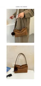 Brown suede shoulder bag detail view featuring soft fabric and fluffy plush ball pendant.