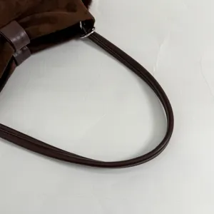 Close up of brown suede shoulder bag strap, detailed view of retro design handbag hardware.