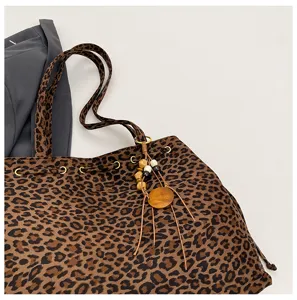 Koreanische minimalistische Leoparden-Torettasche mit Holzperlen-Anhänger und Metallösen.