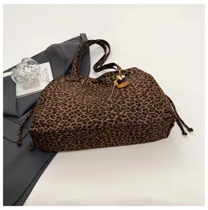 Nahaufnahme des stilvollen Leopardenmuster-Shoppers mit Kordelzug und Zieranhängern.
