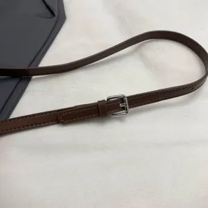 Brown leather handbag strap detail with adjustable silver metal buckle and neat edge stitching.