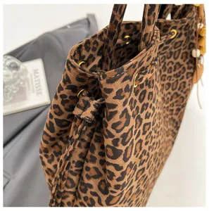 Detailansicht der Leo-Muster Tasche, weiche Wildleder-Textur, Kordelzug und Metallösen.