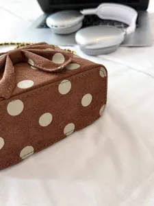 Brown suede polka dot crossbody bag with cute bow and chain strap for women chic daily use.