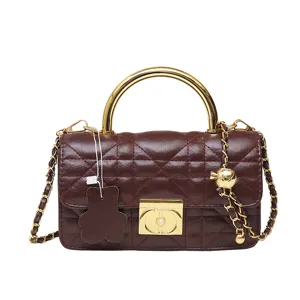 Dunkelrote gesteppte Ledertasche Detail, goldene Kette, Metallgriff, elegantes Design.