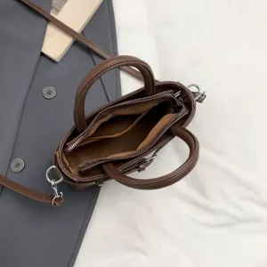 Brown mini tote shoulder bag detail showing interior compartment zipper and sturdy handles.