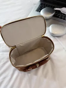 Detailed view of the brown cosmetic box bag featuring herringbone lining and a cute bow.