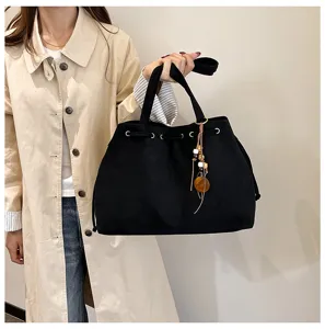 Schwarze Canvas-Tragetasche Detailansicht, lässige Schulterhandtasche mit Holzperlen.