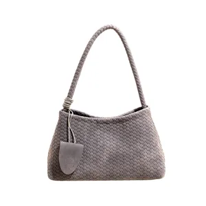 Nahaufnahme der grauen gewebten Achseltasche, die exquisite geflochtene Ledertextur zeigt.