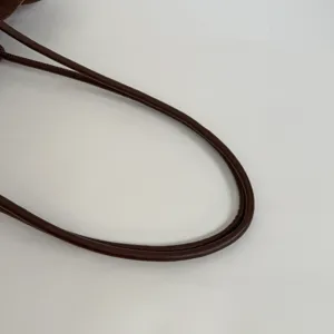 Close-up detail of the smooth dark brown leather bag handle showing neat stitching.