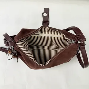Detailed view of the brown suede tote bag showing striped interior lining and zipper pocket.