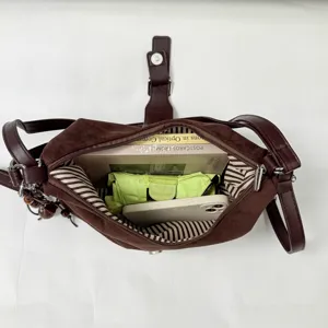 Brown suede shoulder bag interior detail showing large capacity and striped lining design.
