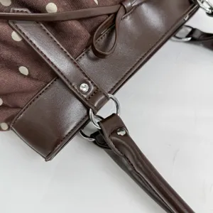Brown polka dot tote bag with bow detail and leather shoulder strap for women daily wear.