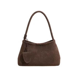 Braune geflochtene Ledertasche Detail, elegante Hobo-Form mit knotenförmigem Griffakzent.