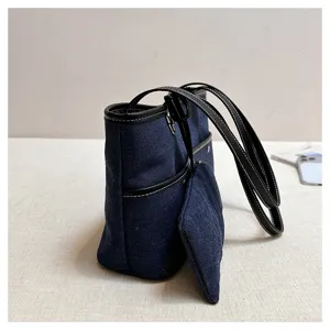 Λεπτομερής άποψη της casual τσάντας tote από τζιν με δερμάτινη επένδυση και πλαϊνή τσέπη.