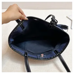 Λεπτομέρεια εσωτερικού τσάντας tote denim με μαύρη δερμάτινη επένδυση και τσέπη.