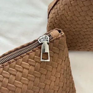 Braune gewebte Handtasche Detailansicht mit weicher Textur und edlem Metallreißverschluss.