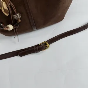 Retro brown suede shoulder bag detail with adjustable metal buckle and cute wooden bead charms.