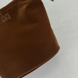 Καφέ βελούδινη τσάντα καλλυντικών λεπτομέρεια, απαλή υφή, vintage τσάντα κοντινό πλάνο.