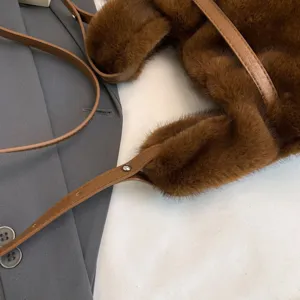 Chic brown plush shoulder bag detail showing soft faux fur texture and elegant leather straps.