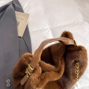 Borsa a mano marrone in morbido peluche con manico in pelle e catena elegante.