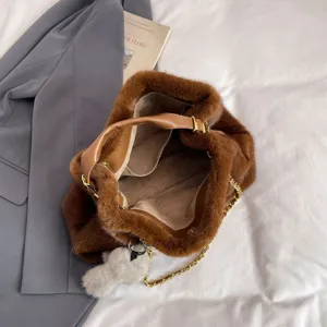 Dettaglio borsa in peluche marrone con morbida pelliccia sintetica, manico in pelle e catena.