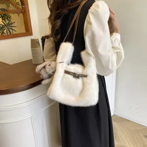 Detailed shot of a fluffy white plush shoulder bag with brown strap and cute doll charm in a cafe.
