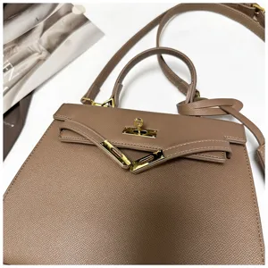Nahaufnahme der taupefarbenen Handtasche aus Leder mit edlen goldfarbenen Beschlägen im Detail.