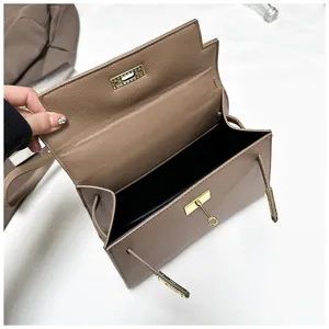 Detailaufnahme der braunen Lederhandtasche mit goldenem Verschluss und offenem Innenfach.