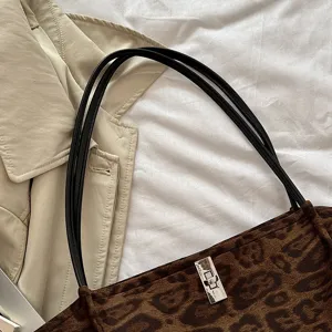 Stylish retro leopard print tote bag with black handles and metal lock detail for daily wear.