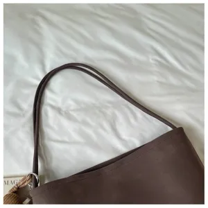 Brown suede-like shoulder tote bag detail showcasing fine double straps and clean stitching.