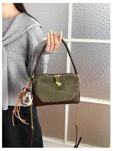 Stylish green brown patchwork shoulder handbag with plush pompom charm and chain strap.