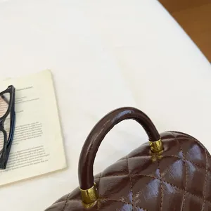 Borsa a mano trapuntata marrone vintage dettaglio, elegante borsa a spalla con dettagli metallici.