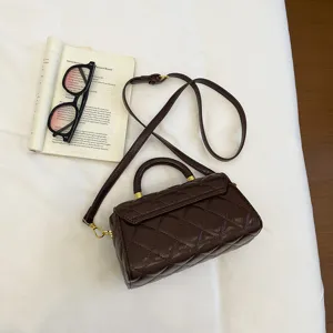 Dettaglio borsa a tracolla trapuntata marrone retrò, elegante borsa a scatola con manico.