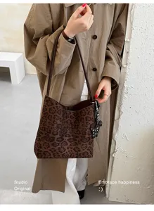 Stylish leopard print suede bucket bag with shoulder strap and chic handbag design.
